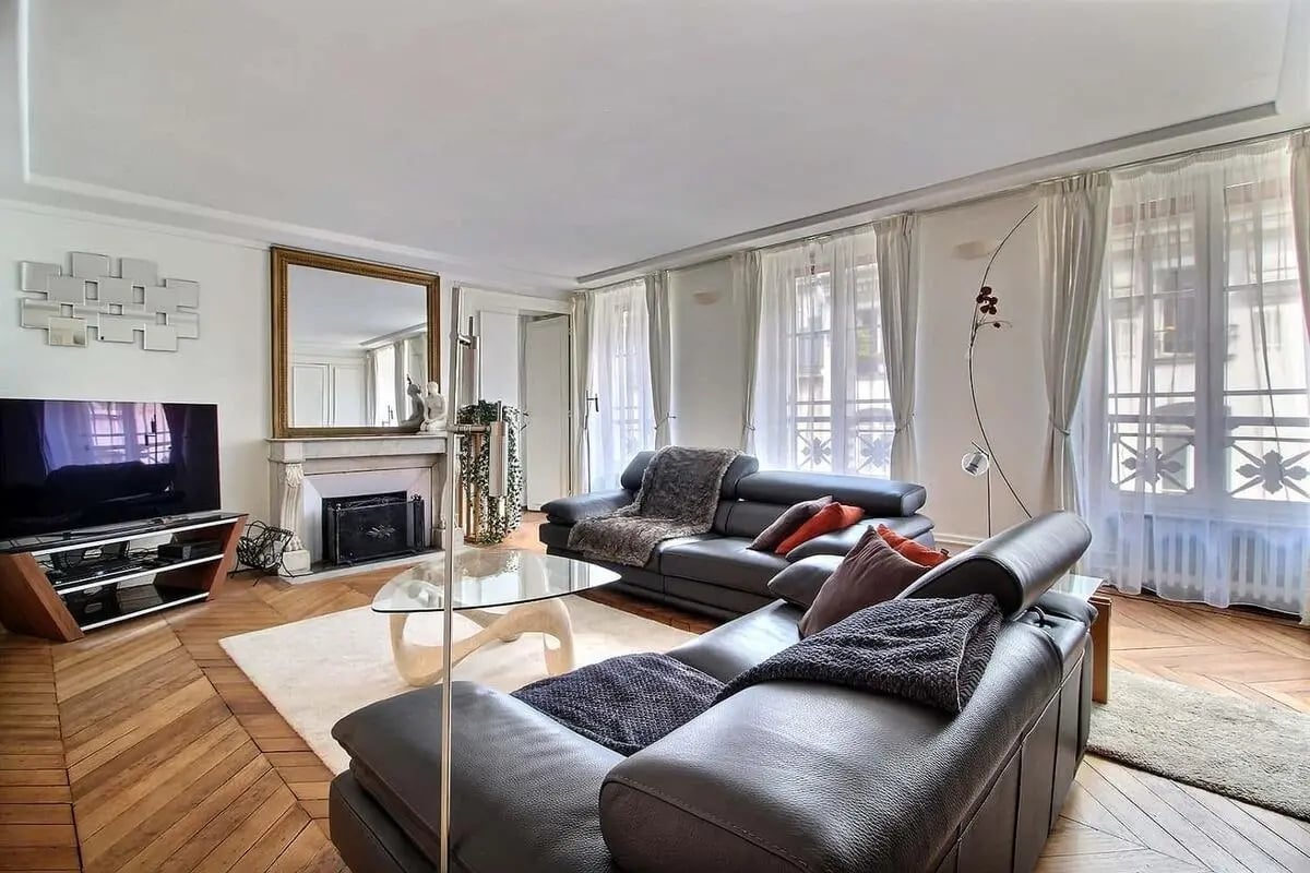 Leather sofas mirrored fireplace large windows living room at Apartment in Rue Saint-Roch, 75001 Paris, France in Paris Student Accommodation