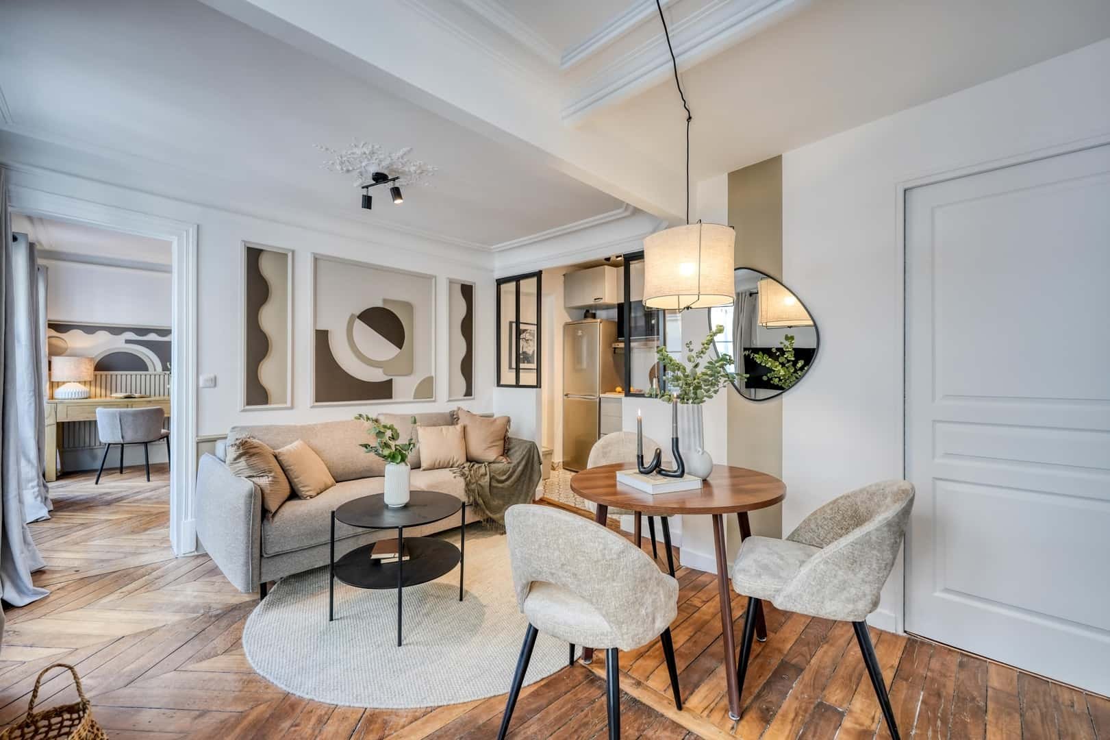 Sofa dining chairs artwork kitchen living area at Apartment in 17 Rue du Faubourg Montmartre, 75009 Paris, France in Paris Student Accommodation