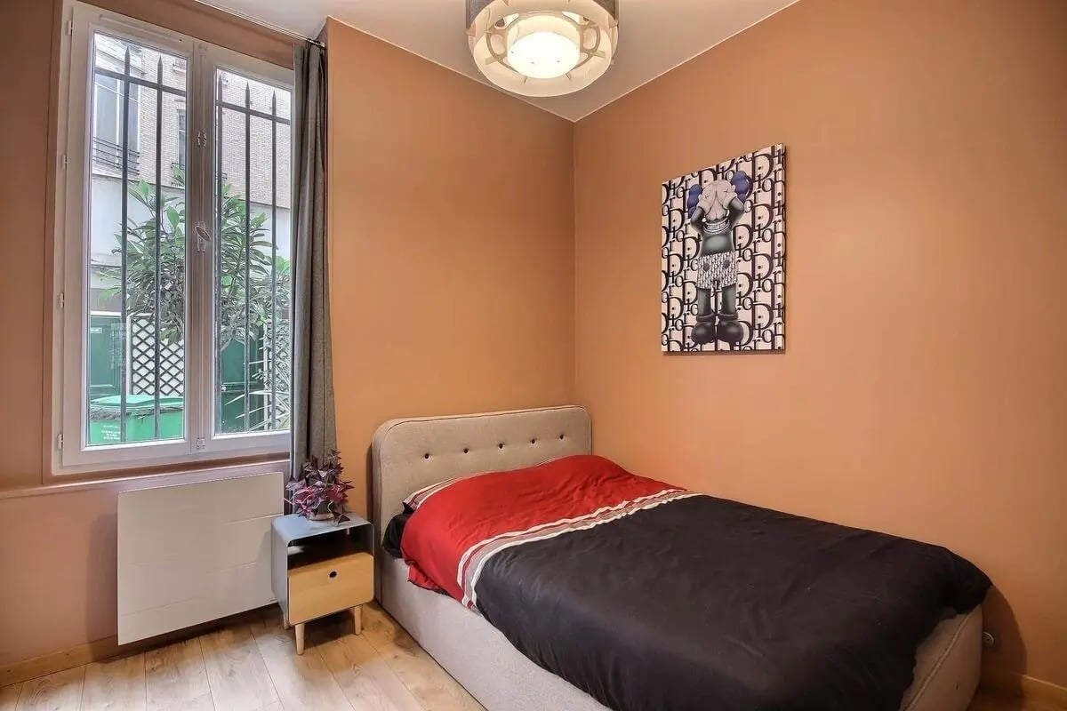 Bed with red and black bedding bedside table bedroom at Apartment in Rue de Rome, 75008 Paris, France in Paris Student Accommodation