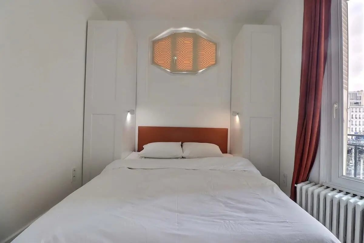 Bed with pillows wardrobes lamps abstract panel Bedroom at Apartment in Rue Boursault, 75017 Paris, France in Paris Student Accommodation