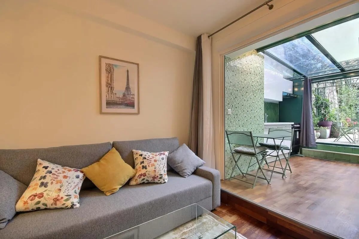 Sofa with pillows glass table green kitchen living room at Apartment in Rue Jean Nicot, 75007 Paris, France in Paris Student Accommodation