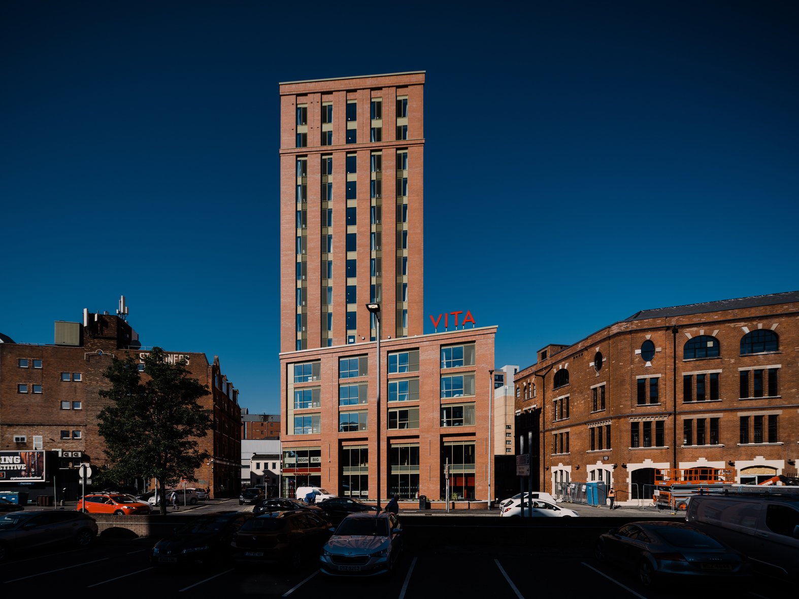 Tall brick building with Vita sign exterior at Vita Student Bruce Street in Belfast Student Accommodation