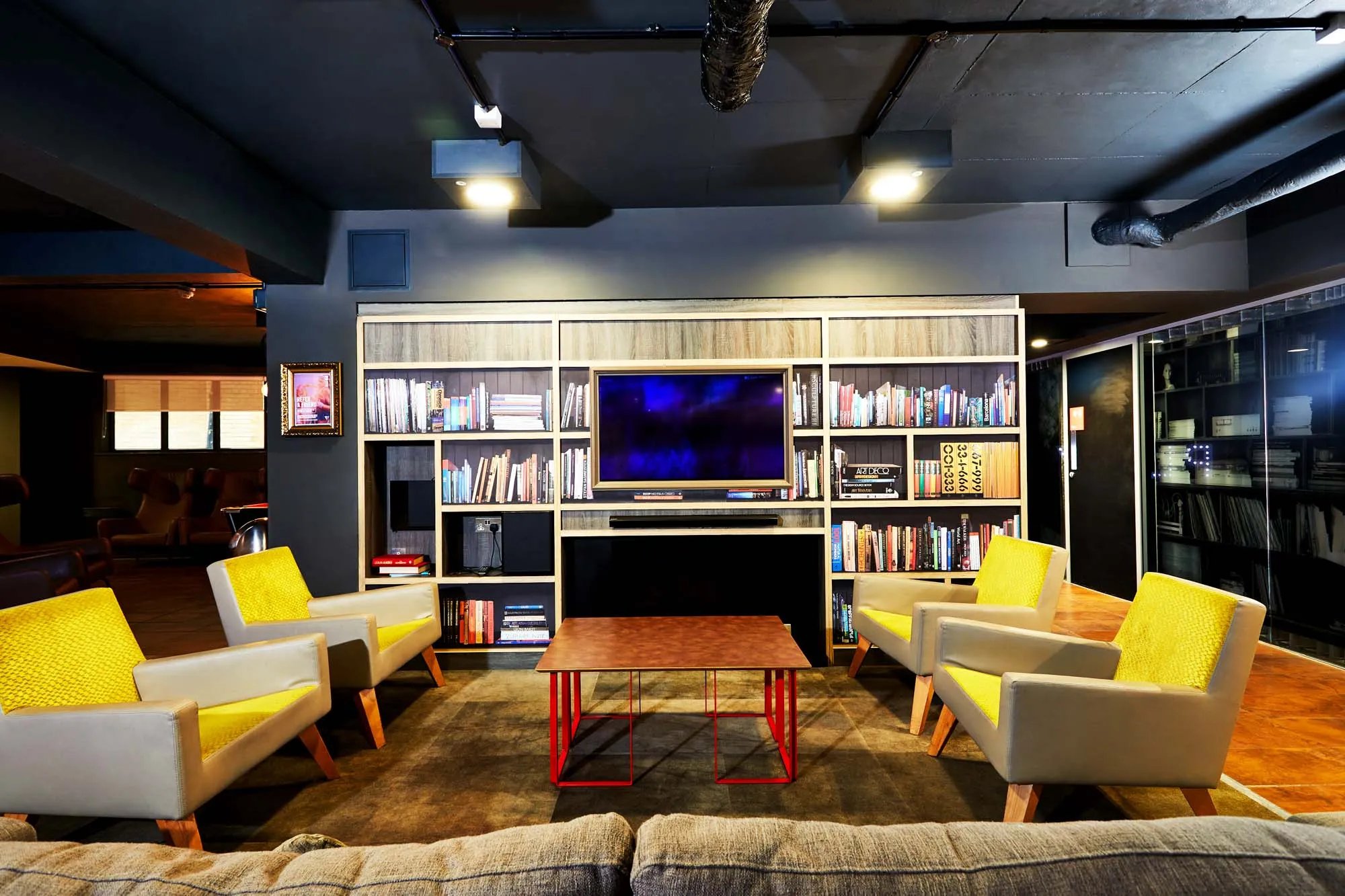 Four chairs bookshelves TV table common area at Vita Student Zed Alley in Bristol Student Accommodation