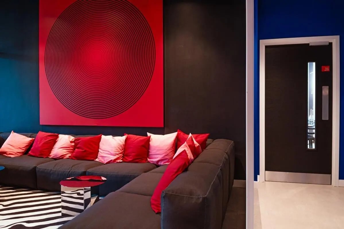 Sofa pillows red art and striped rug living room at Vita Student Copper Towers in Coventry Student Accommodation
