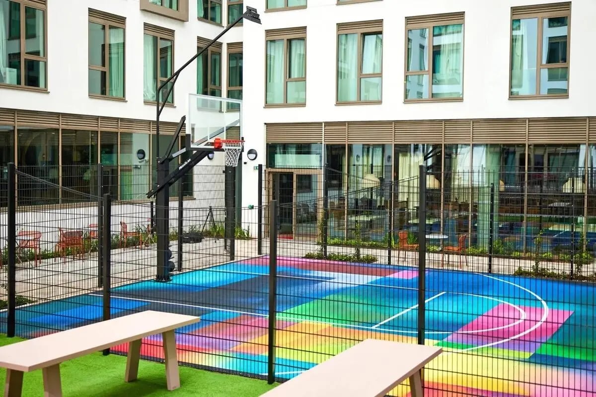 Basketball court with colorful court and benches playing area at Vita Student Cannon Park Warwick in Coventry Student Accommodation