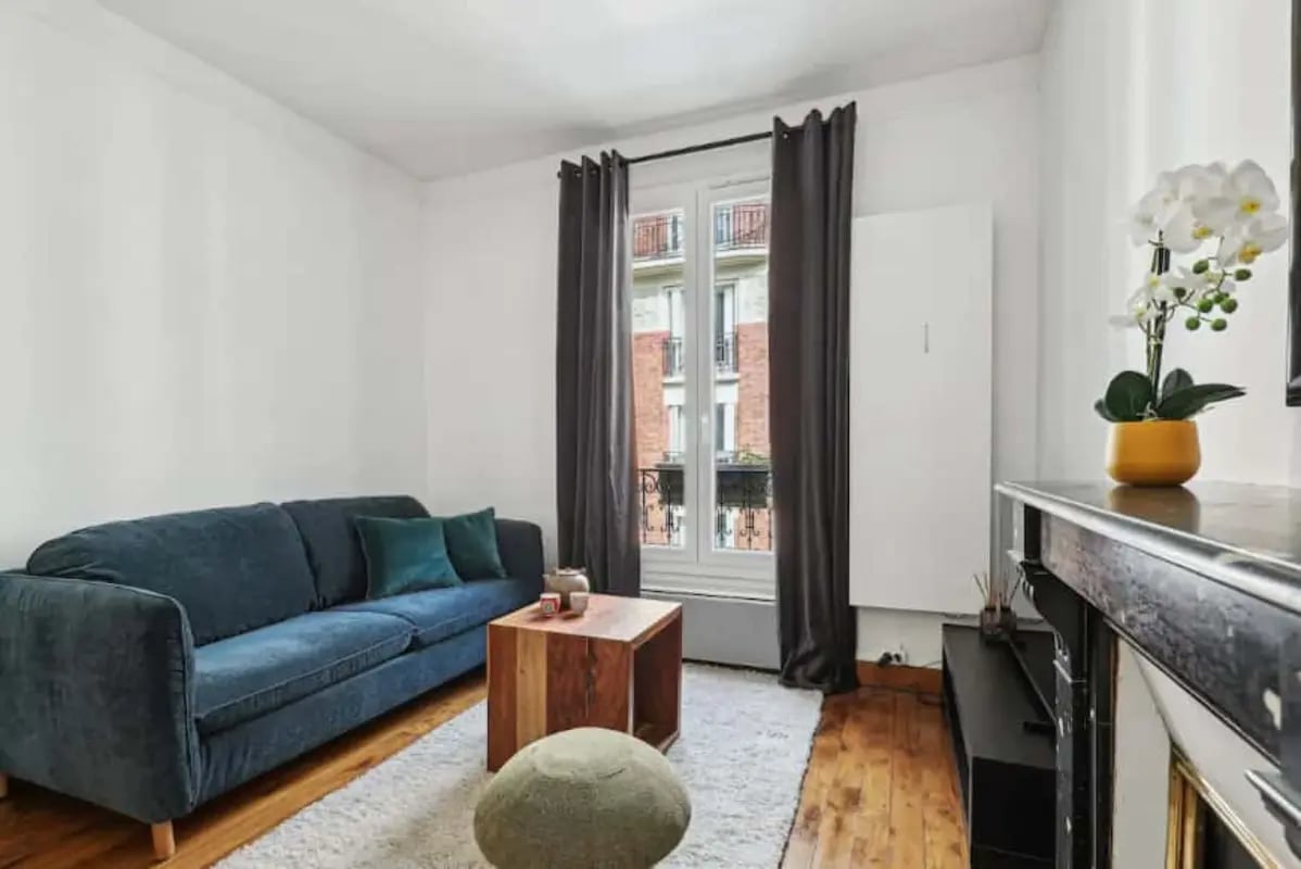 Blue sofa wooden coffee table white rug living room at Apartment in 83 Rue Lamarck, 75018 Paris, France in Paris Student Accommodation