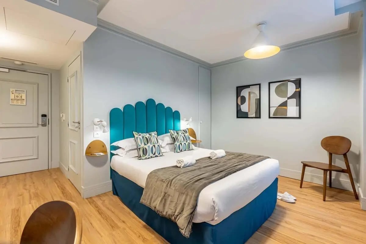 Bed with pillows throw towels and artwork Bedroom at Studio in 5 Rue Lécluse, 75017 Paris, France in Paris Student Accommodation