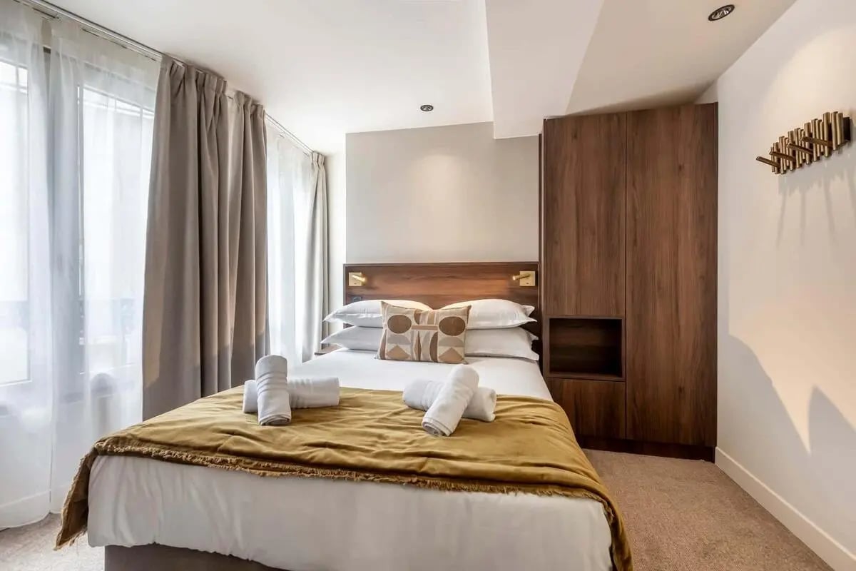 Bed with towels wardrobe and wall hooks bedroom at Studio in 2 Rue Geoffroy-Marie, 75009 Paris, France in Paris Student Accommodation