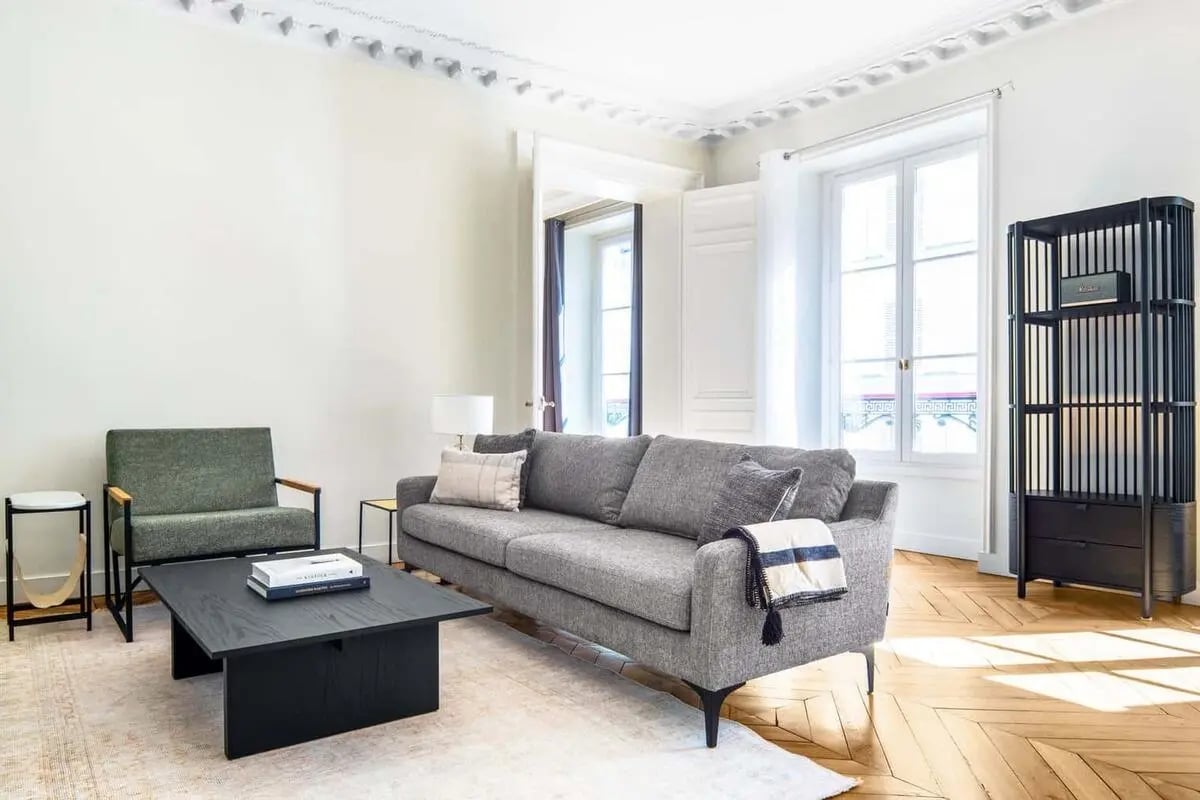 Gray sofa armchair black coffee table living room at Apartment in 26 Rue las Cases, 75007 Paris, France in Paris Student Accommodation