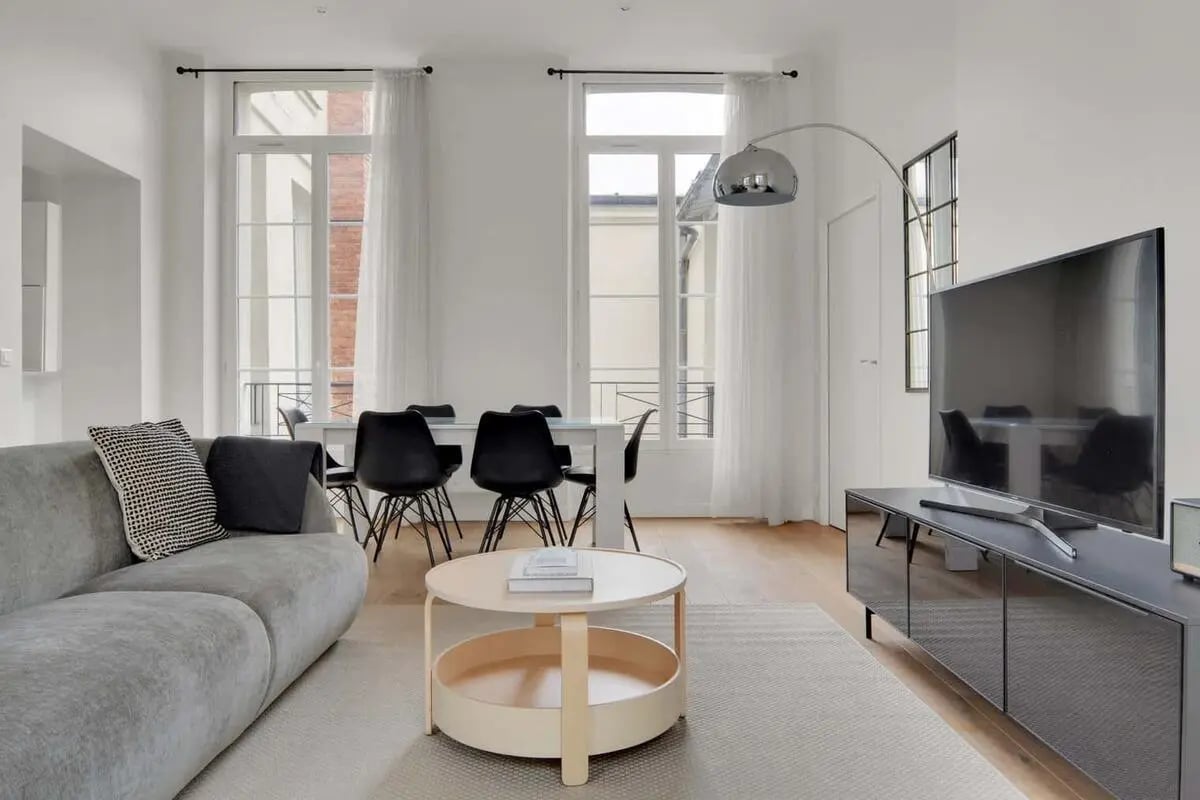 Grey sofa coffee table dining set television living room at Apartment in 20 Rue Poissonnière, 75002 Paris, France in Paris Student Accommodation