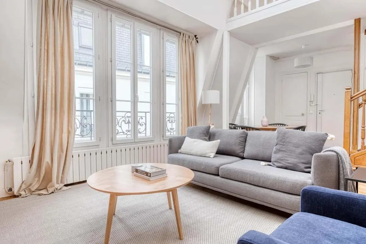 Grey sofa oval table large windows living room at Apartment in 47 Bd Saint-Marcel, 75013 Paris, France in Paris Student Accommodation