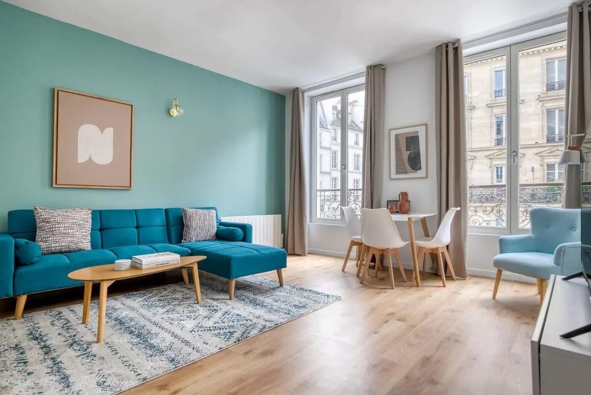 Turquoise sofa coffee table rug dining table living room at Apartment in 4 Rue Réaumur, 75003 Paris, France in Paris Student Accommodation
