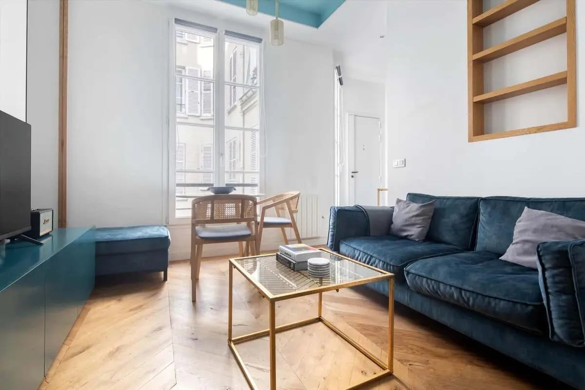 Blue sofa glass coffee table wood floor living room at Apartment in 12 Rue Cambon, 75001 Paris, France in Paris Student Accommodation