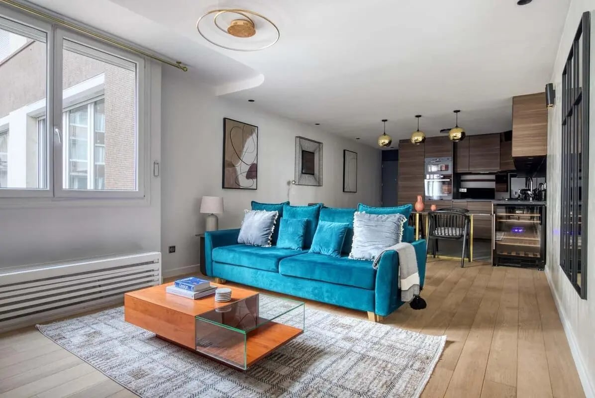 Teal sofa coffee table artwork modern kitchen living room at Apartment in 39 Rue de la Grange aux Belles, 75010 Paris, France in Paris Student Accommodation