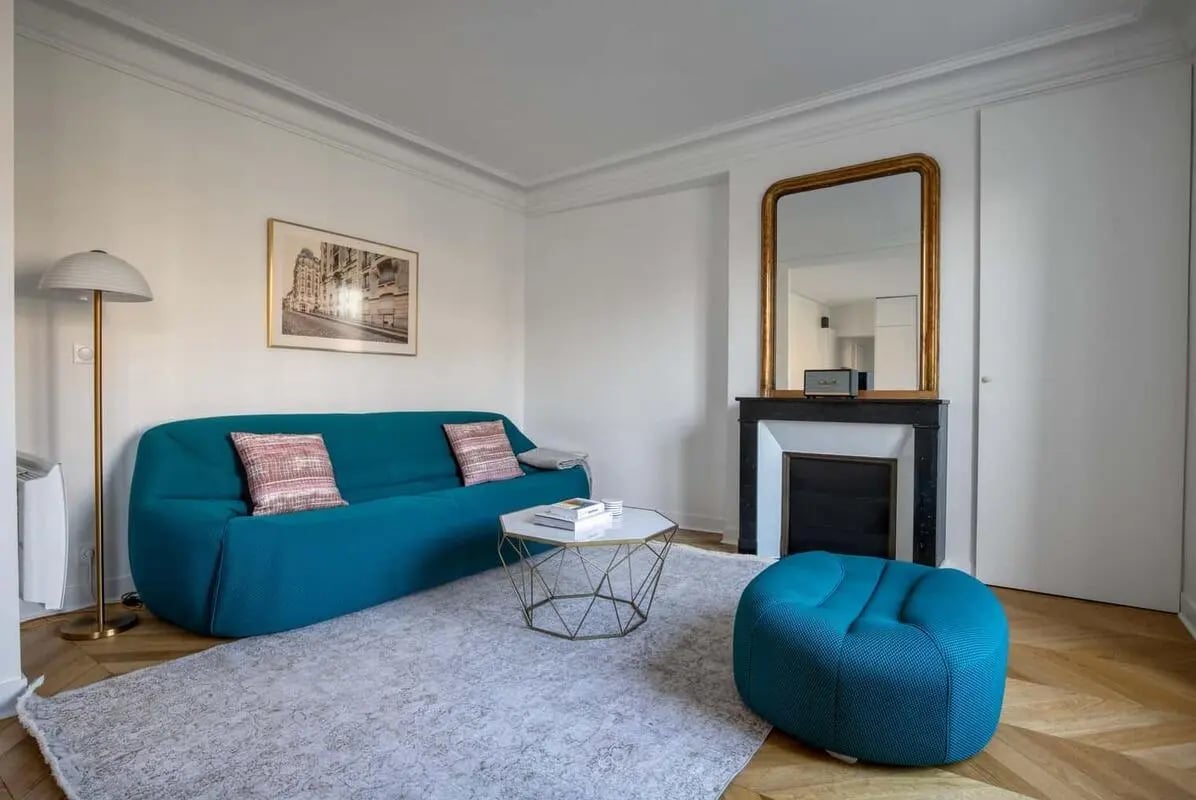 Blue sofa fireplace and artwork living room at Apartment in 28 Av. de Breteuil, 75007 Paris, France in Paris Student Accommodation