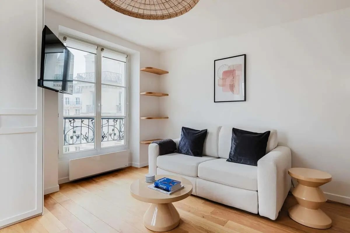 White sofa black pillows art picture shelves living room at Apartment in 18 Rue Debelleyme, 75003 Paris, France in Paris Student Accommodation