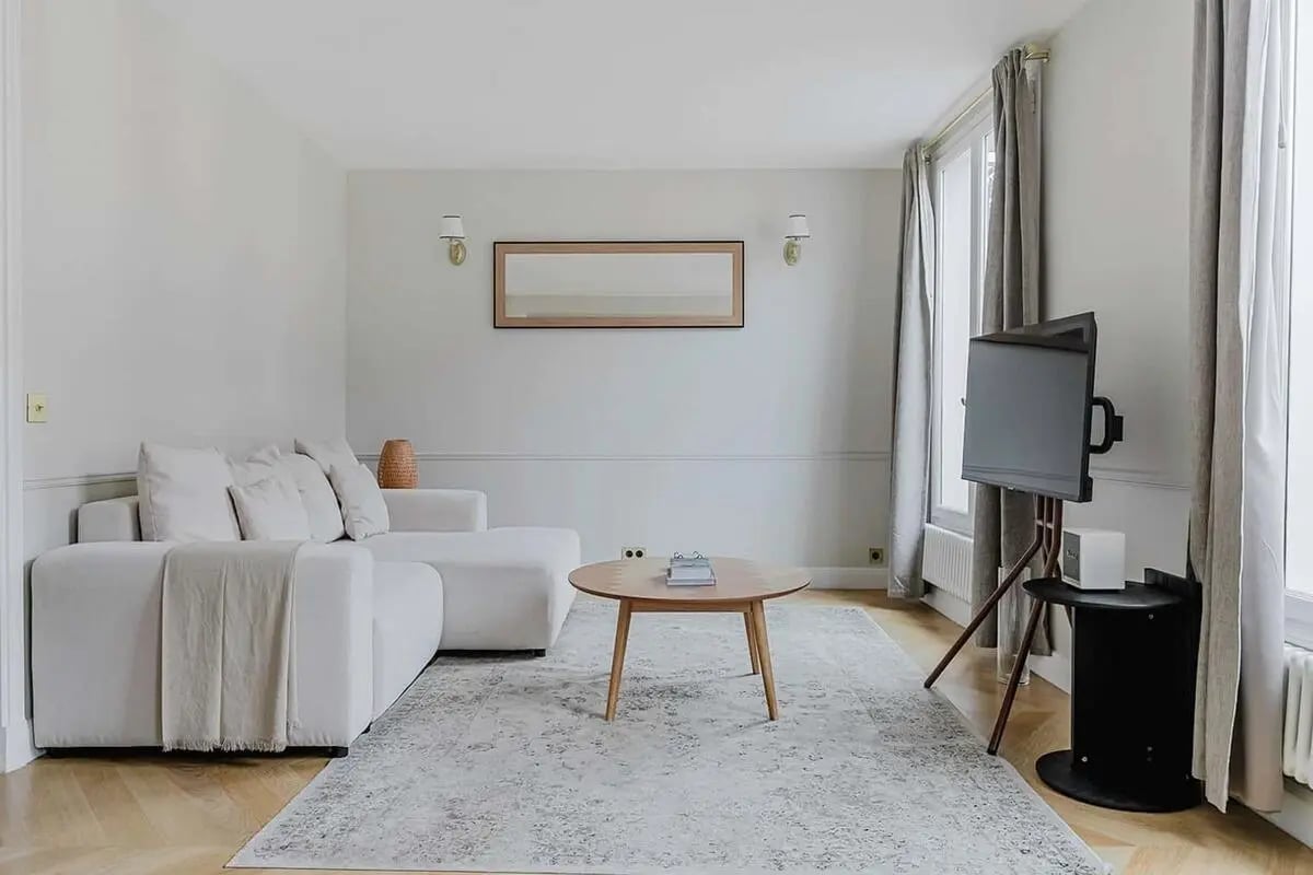 White sofa coffee table rug and TV living room at Apartment in 2 Rue Volney, 75002 Paris, France in Paris Student Accommodation