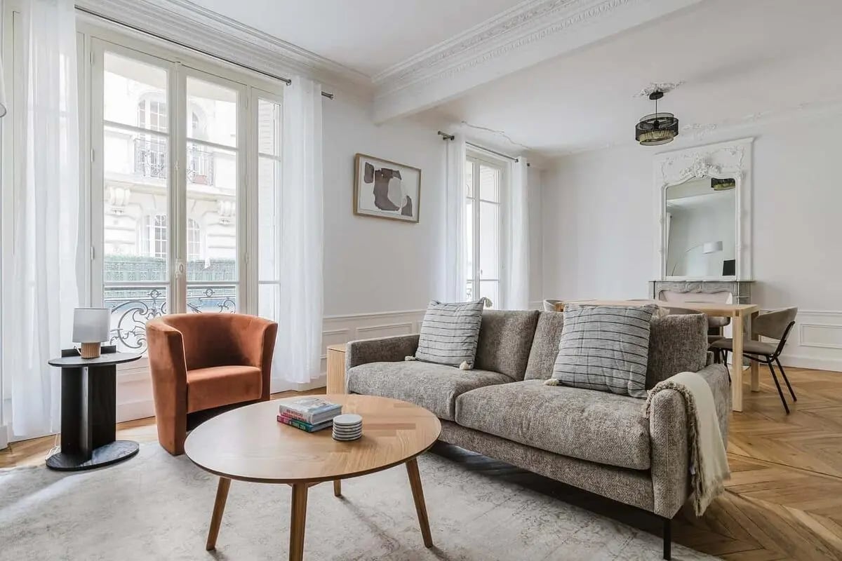 Sofa armchair table with books rug living room at Apartment in 17 Rue la Condamine, 75017 Paris, France in Paris Student Accommodation