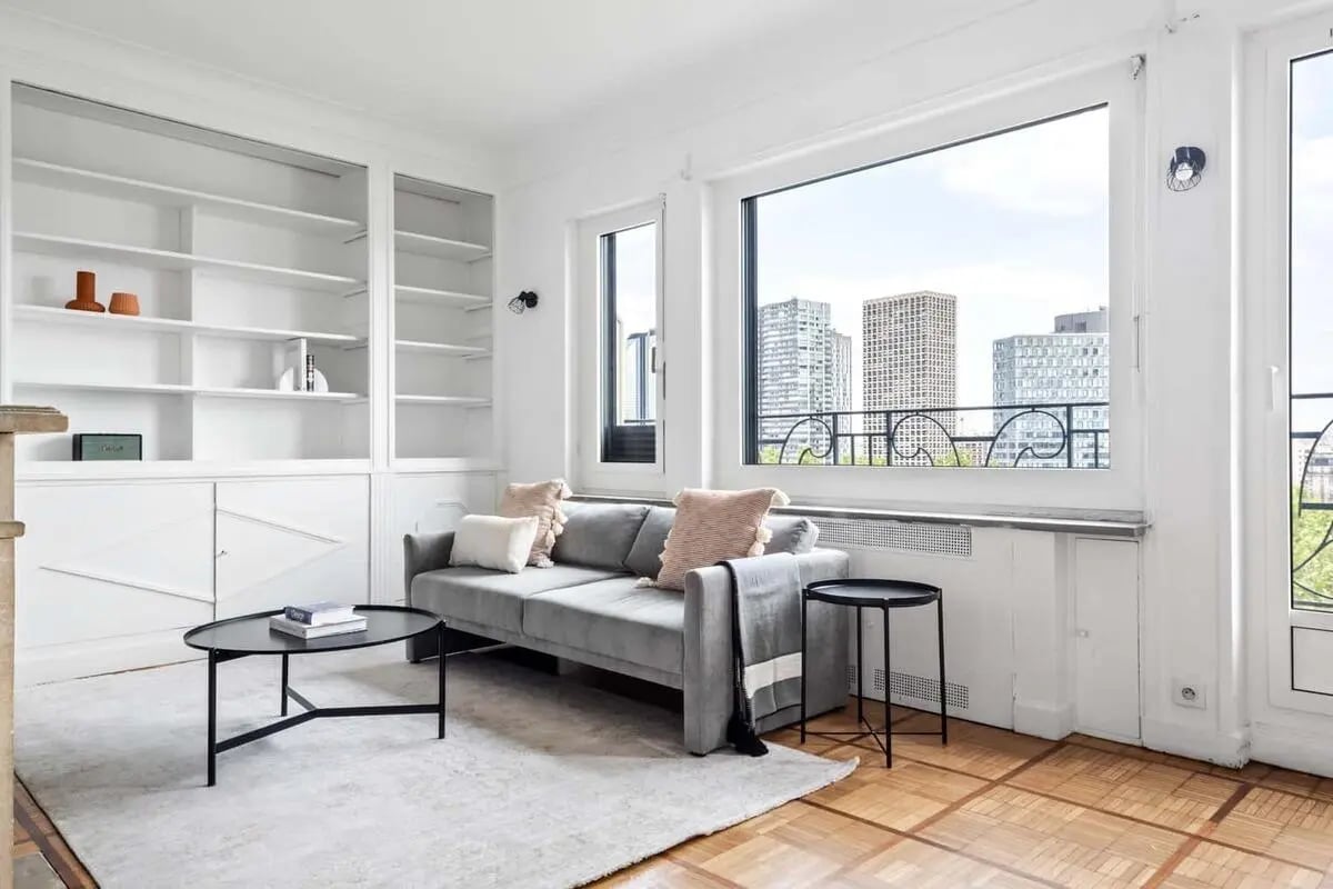 Grey sofa bookshelves and large window living room at Apartment in 60 Quai Louis Blériot, 75016 Paris, France in Paris Student Accommodation