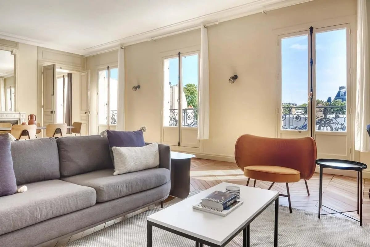 Gray sofa white coffee table orange chair living room at Apartment in 70 Rue de l'Université, 75007 Paris, France in Paris Student Accommodation