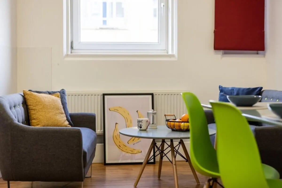 Sofa, artwork, table, chairs, fruit basket, living area at Cranborne House in Bournemouth Student Accommodation