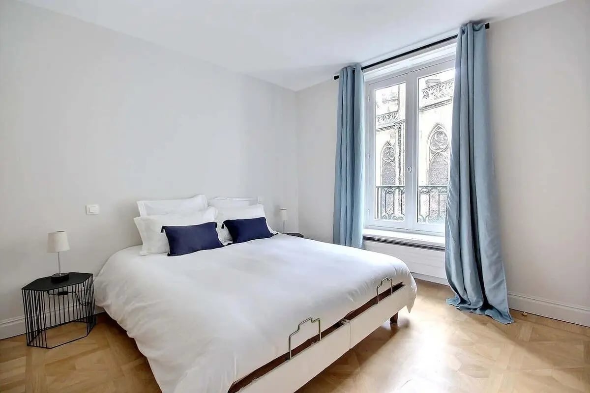 White bed with blue pillows bedside table bedroom at Apartment in Rue Casimir Périer, 75007 Paris, France in Paris Student Accommodation