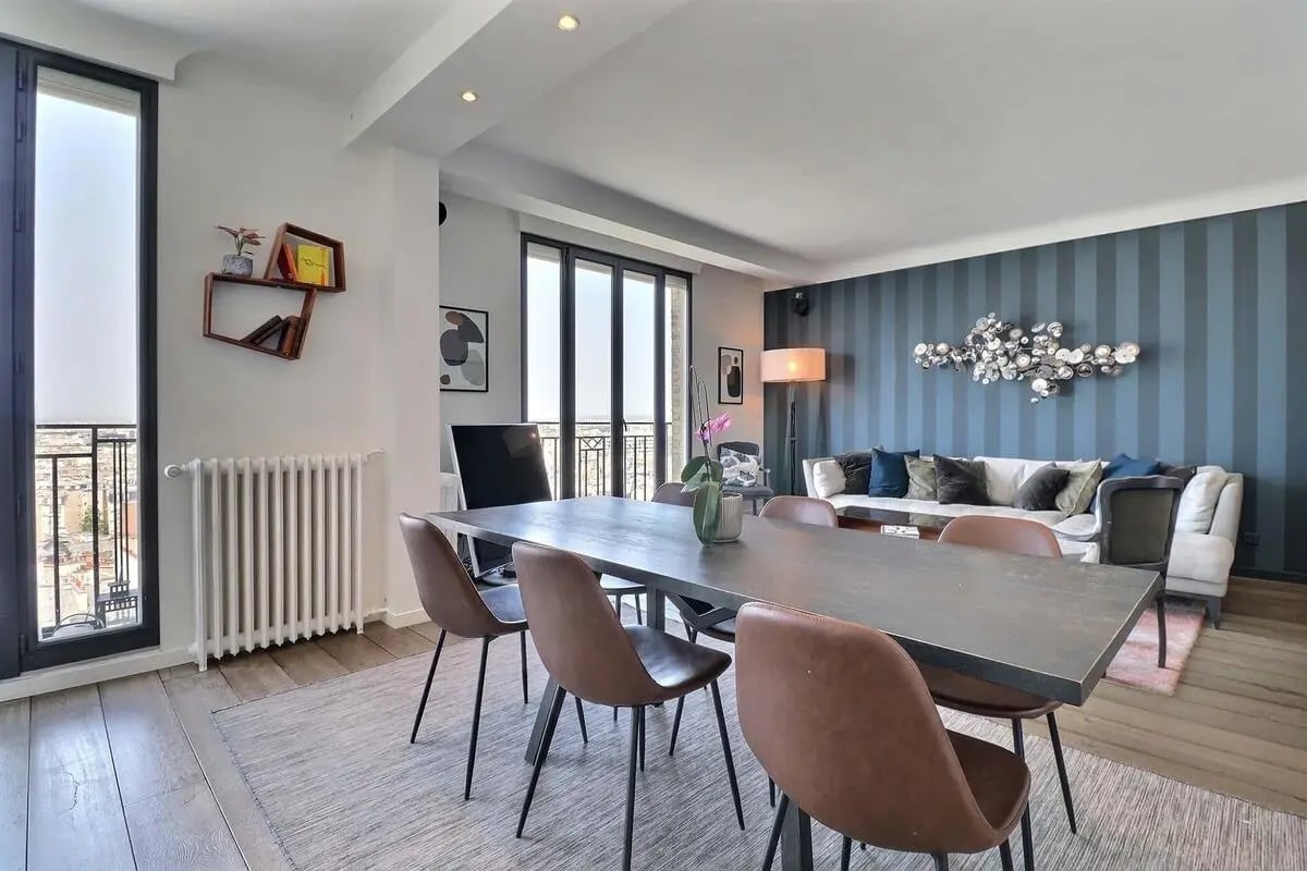 Dining table chairs sofa large windows living room at Apartment in Rue Caulaincourt, 75018 Paris, France in Paris Student Accommodation