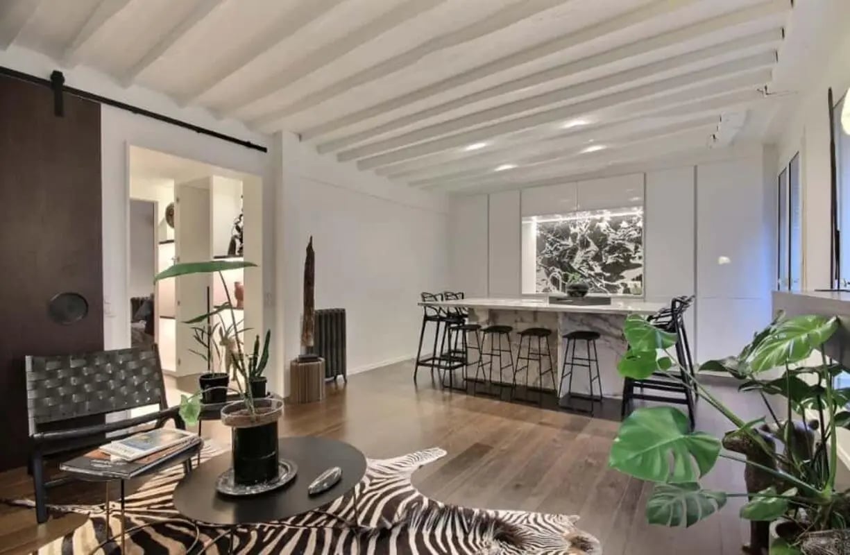 Black chair zebra rug bar stools marble kitchen island living area at Apartment in Rue de Parme, 75009 Paris, France in Paris Student Accommodation