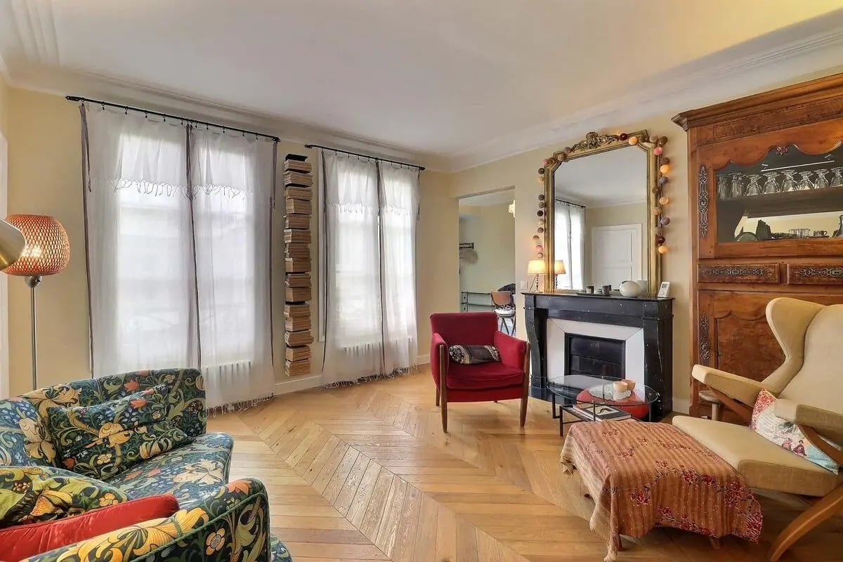 Patterned sofas fireplace mirror and wooden cabinet Living room at Apartment in Rue Clauzel, 75009 Paris, France in Paris Student Accommodation