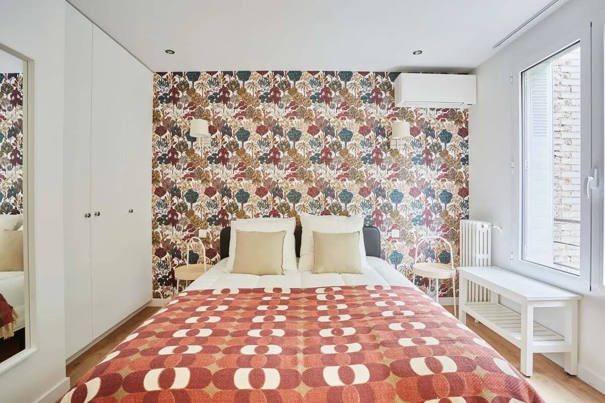 Bed with patterned wallpaper and white closet Bedroom at Rue Degas Paris - Degas Studio in Paris Student Accommodation