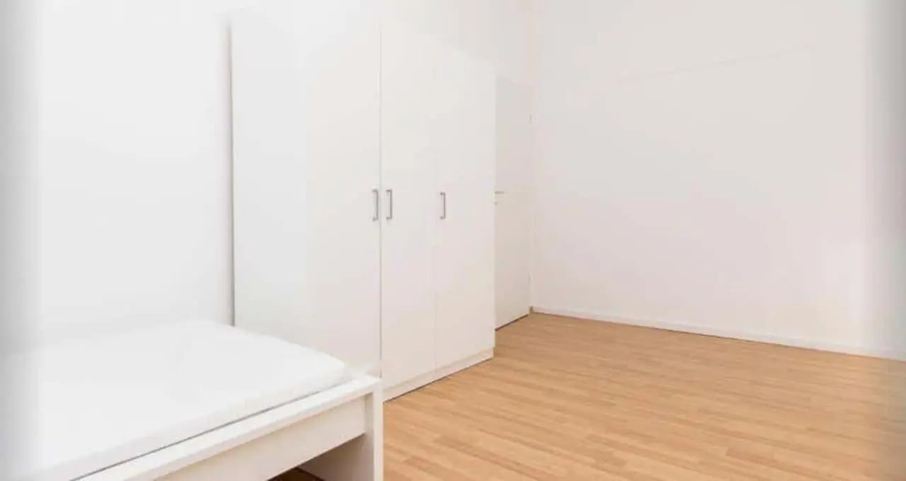 White wardrobe and bed in empty bedroom at Room in Bismarckstraße 72, 10627 Berlin, Germany in Berlin Student Accommodation