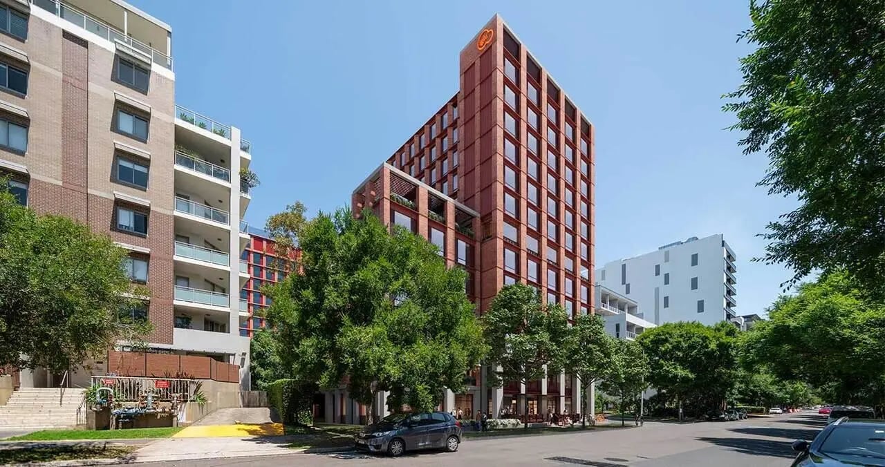 Modern student accommodation buildings with trees exterior at Iglu Mascot Duo in Sydney Student Accommodation