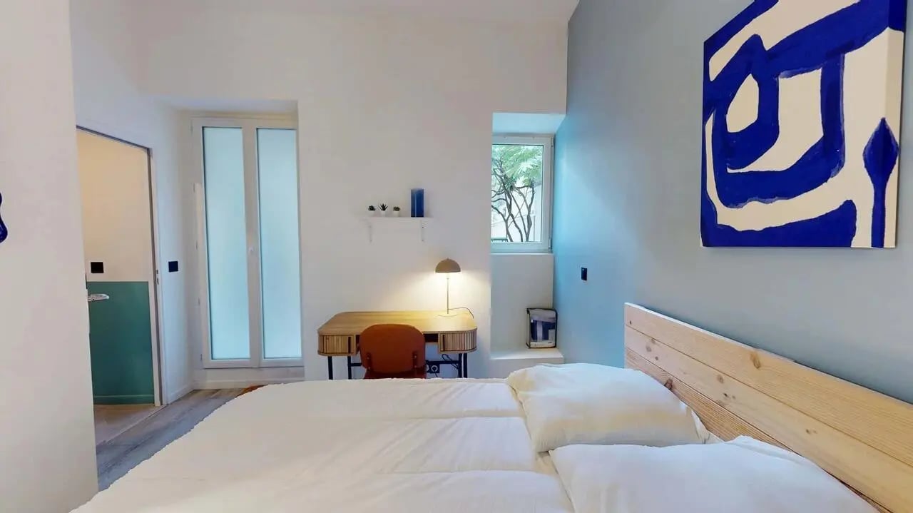 Bed desk chair art and window bedroom at Bovary House - Room S (3) in Paris Student Accommodation