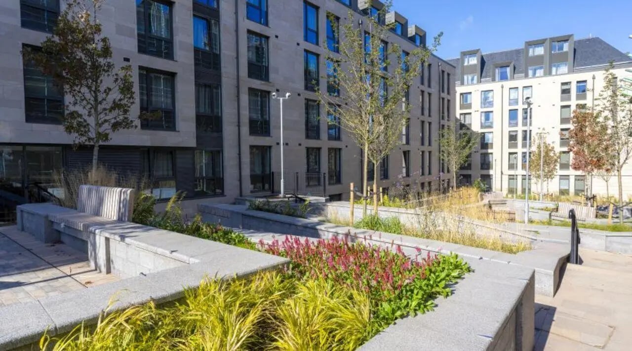 Modern buildings with trees and seating area exterior at iQ The Mont in Edinburgh Student Accommodation