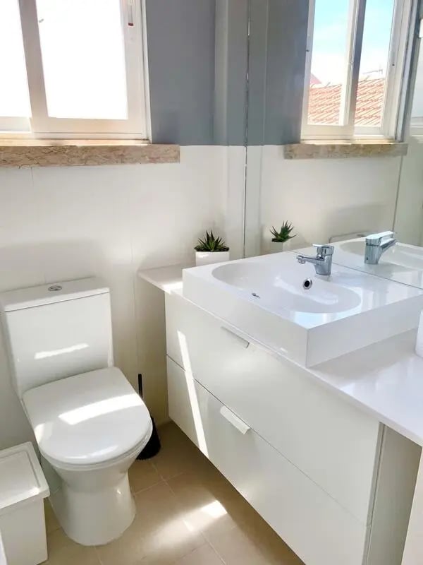 Toilet sink cabinets and plants bathroom at T1 Roma Apartment in Lisbon Student Accommodation