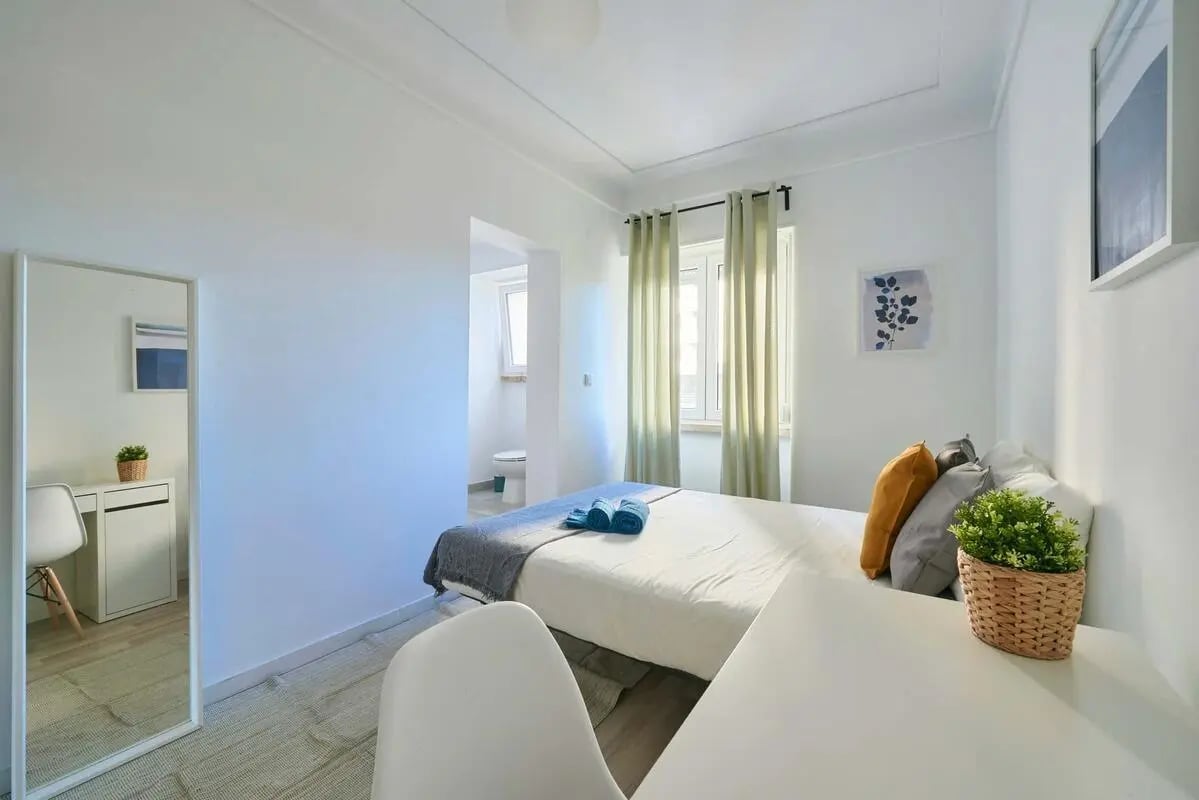 Bed with pillows towels and plant bedroom at Bedroom with private bathroom in a 4-bedroom apartment in Av. de Roma, Lisbon - Room 3 in Lisbon Student Accommodation