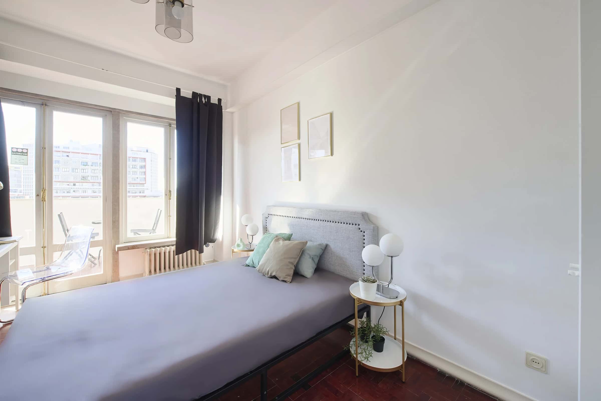 Bed with pillows, bedside table, and window bedroom at Room 1 - Avenida Estados Unidos da America 97 7E in Lisbon Student Accommodation