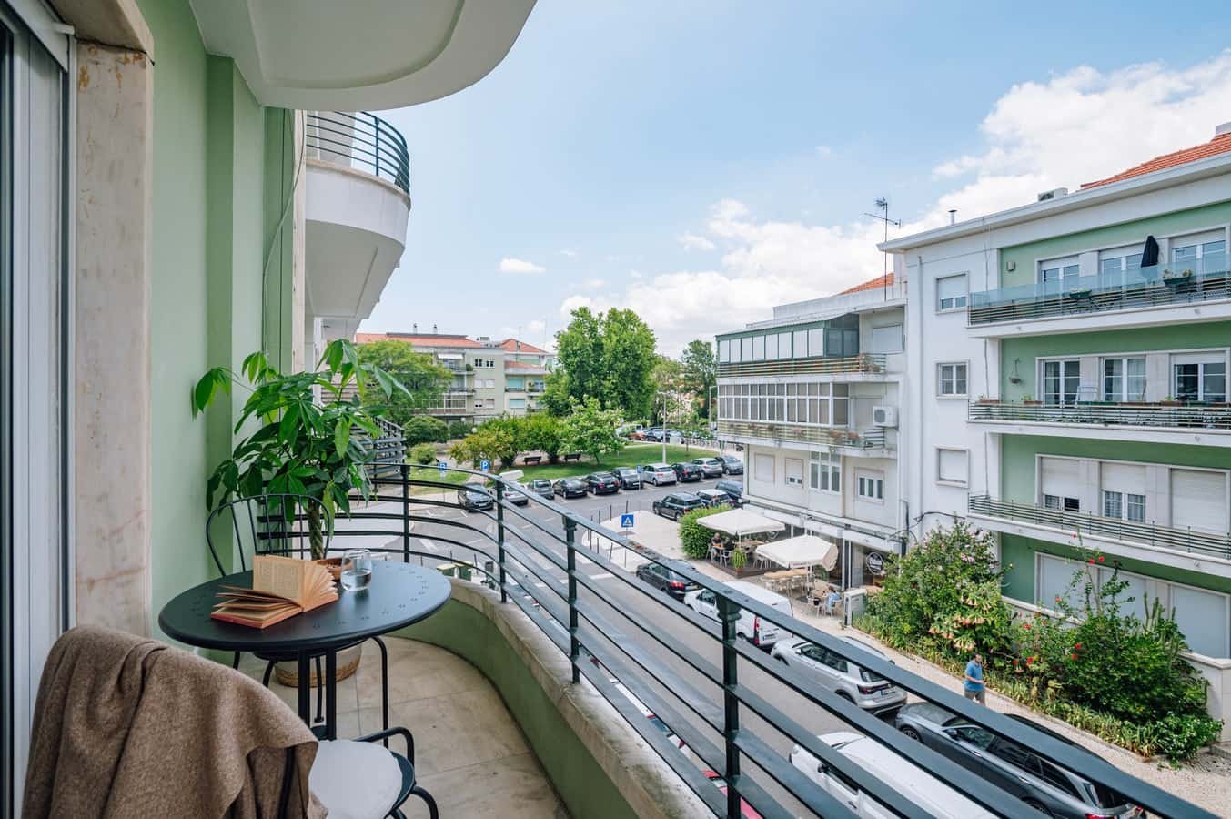 Balcony with table chairs plant overlooking street exterior at 3 bedrooms with balcony in Alvalade in Lisbon Student Accommodation
