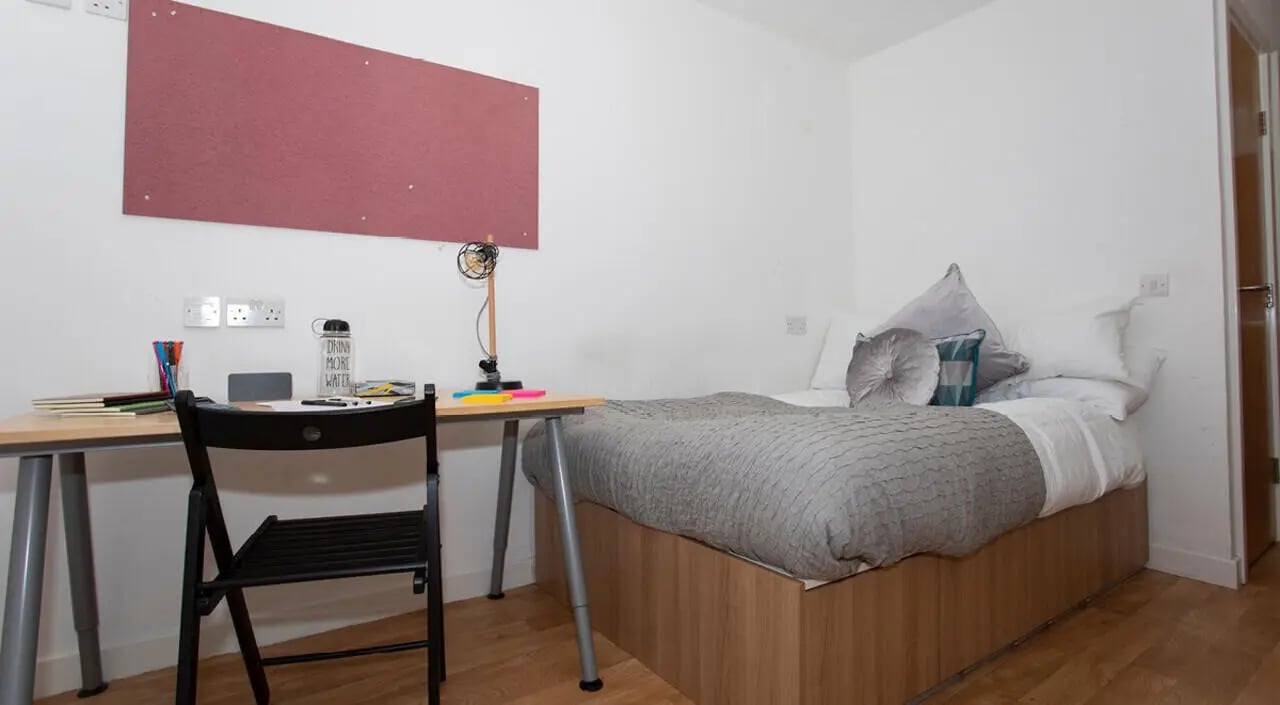 Desk chair bed with grey duvet and pillows bedroom at 200 Cowgate in Edinburgh Student Accommodation