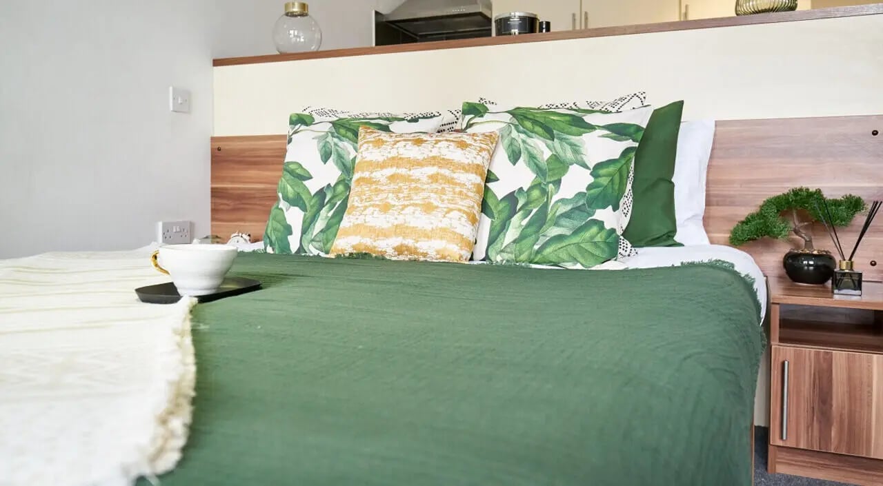 Bed with green blanket plant and cup bedroom at Windsor Court in Liverpool Student Accommodation