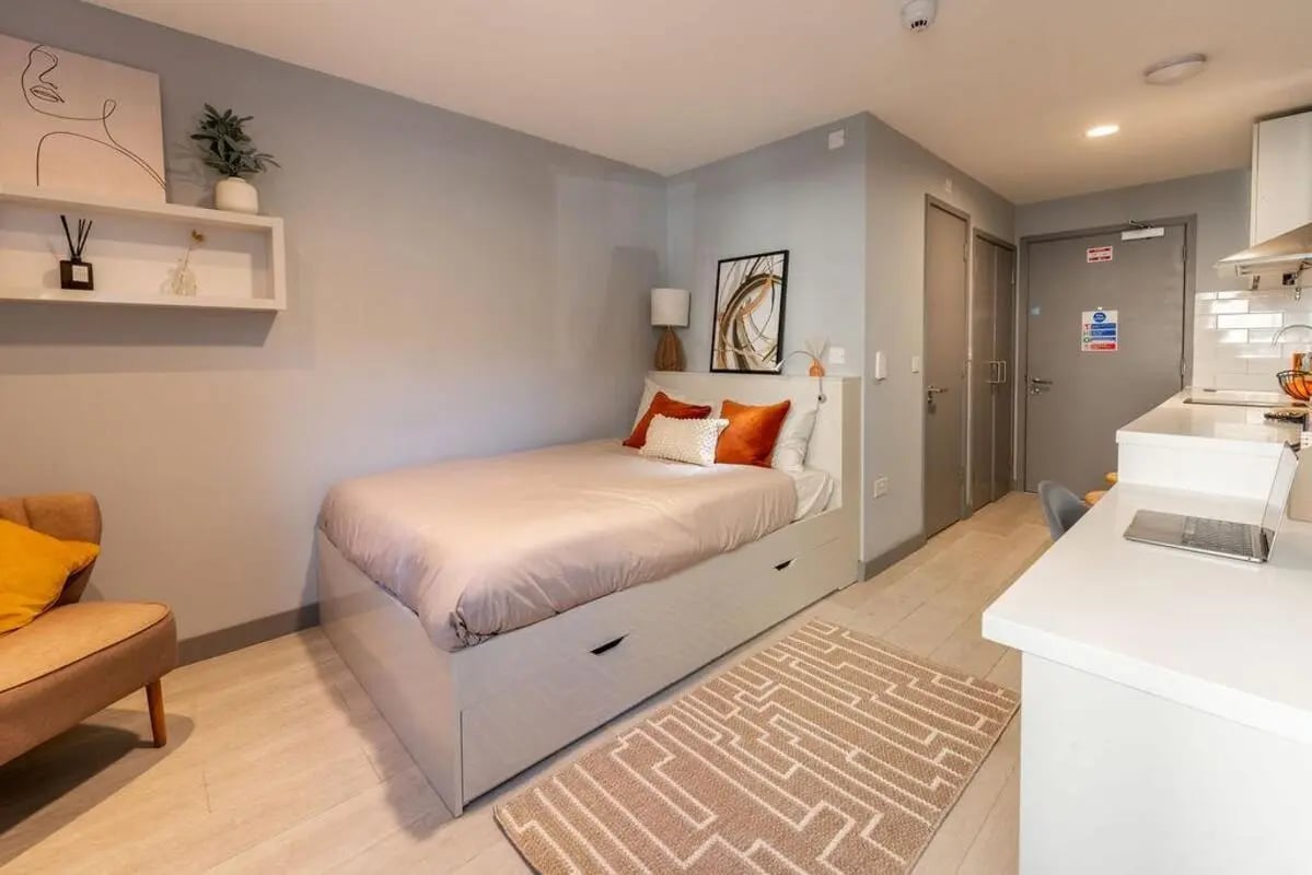 Bed with drawers armchair rug and desk bedroom at The Walls in Southampton Student Accommodation
