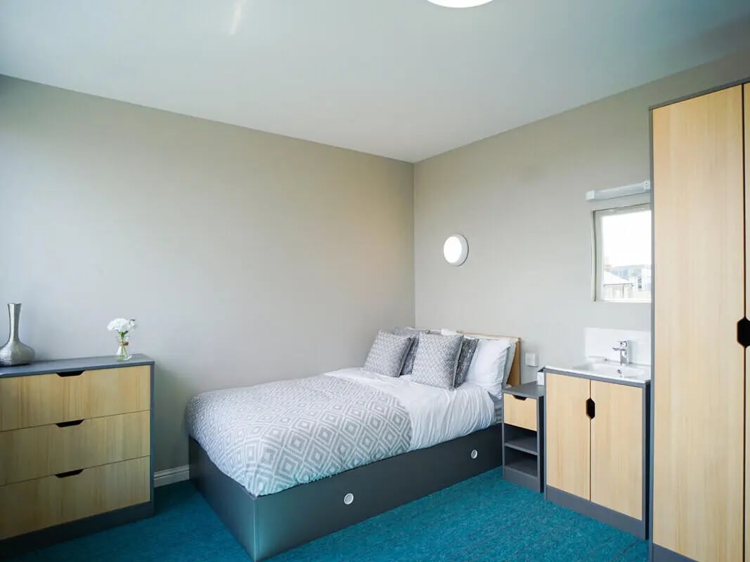 Bed dresser sink and wardrobe bedroom at 8 Roxburgh in Edinburgh Student Accommodation