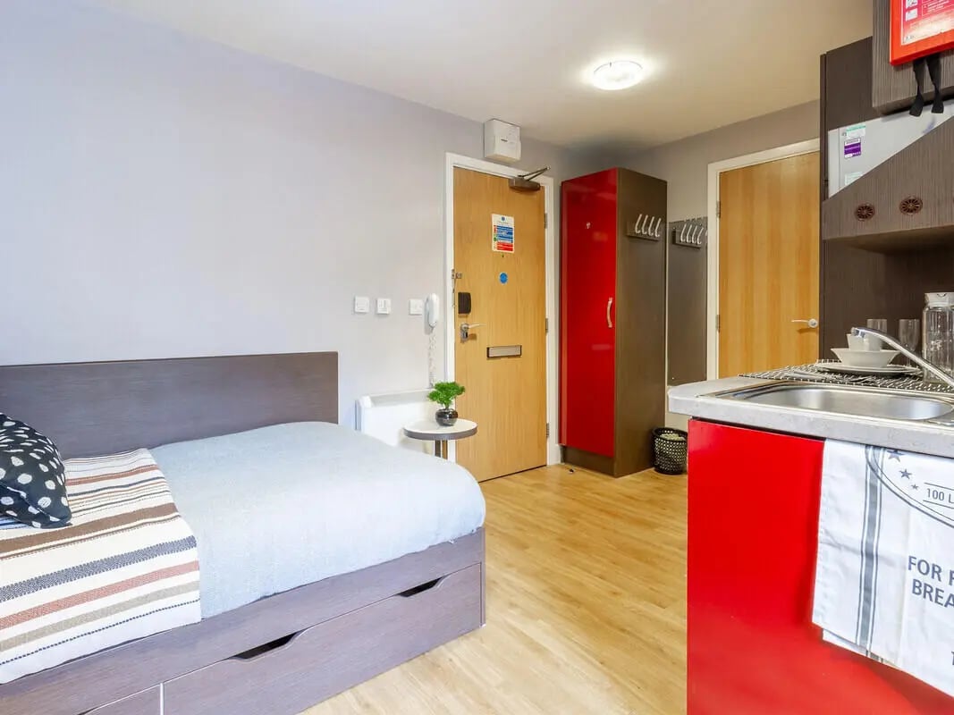 Bed wardrobe door sink kitchen studio at Camden Hawley Crescent in London Student Accommodation