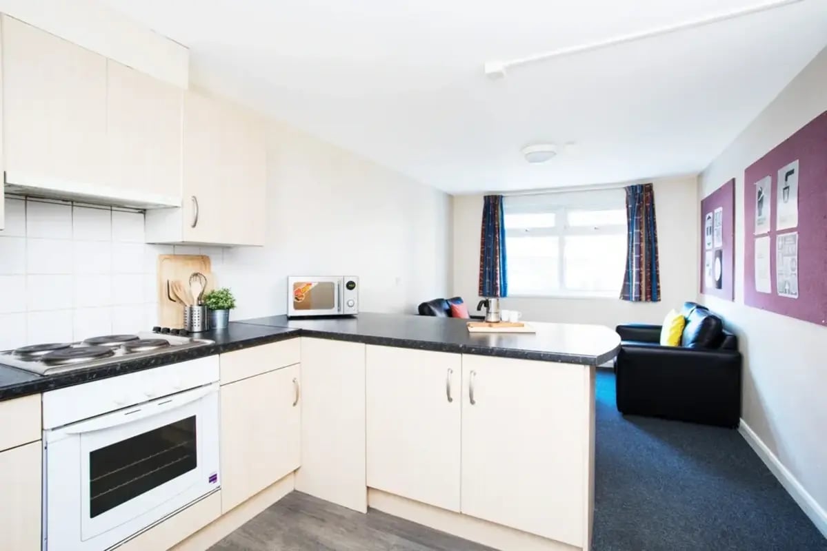 Kitchen with oven microwave couch and window living area at St Martins House in Leicester Student Accommodation