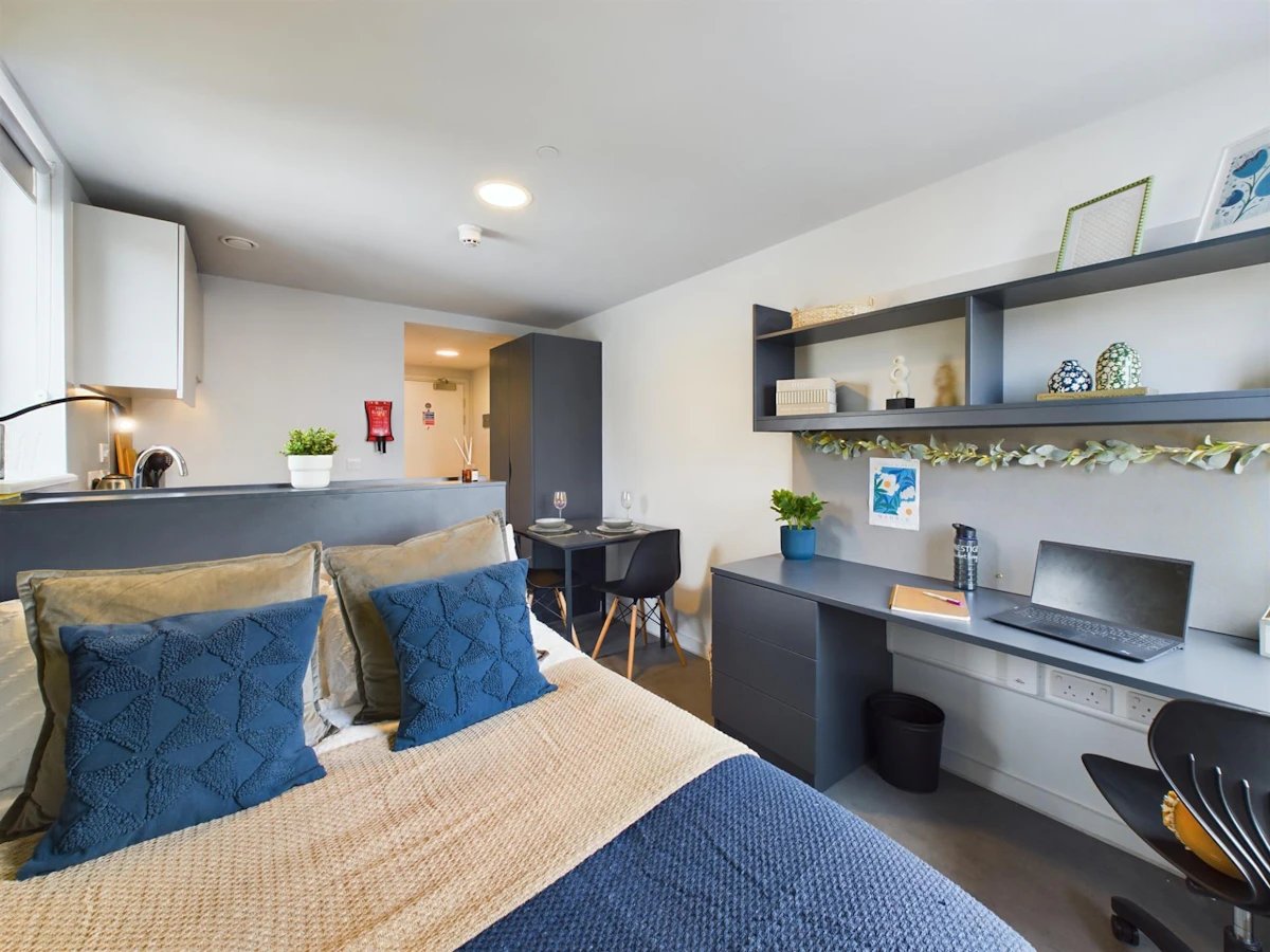 Bed kitchen desk with laptop and shelves studio apartment at Ravilious House in Brighton Student Accommodation
