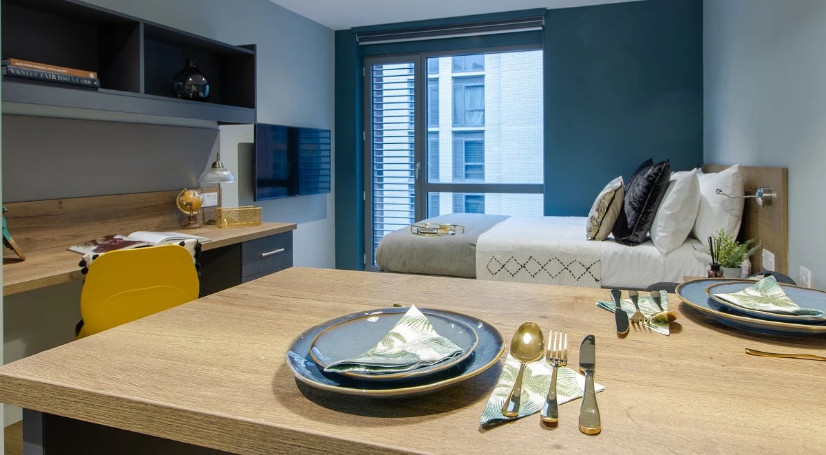 Bed desk and dining table with place settings bedroom at Crown House in Sheffield Student Accommodation