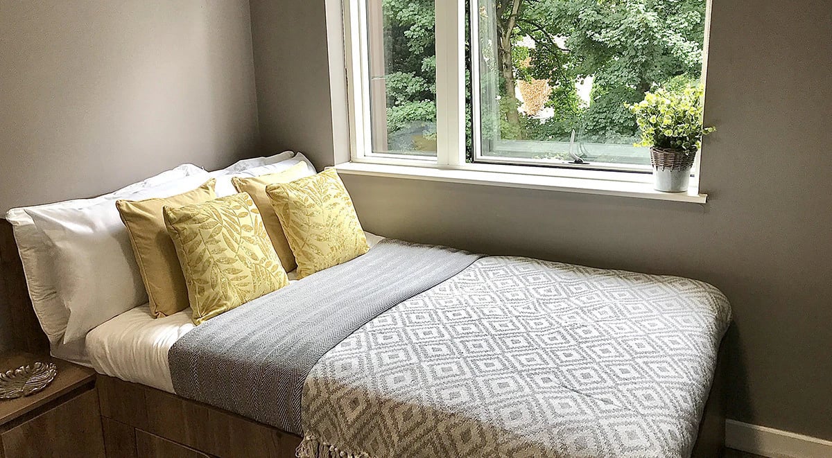 Bed with pillows and plants bedroom at 800 Bristol Road in Birmingham Student Accommodation