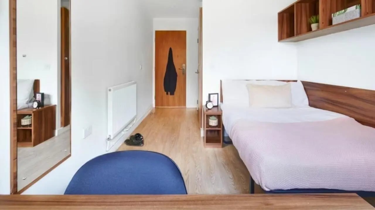 Bed wardrobe and mirror in student room at The Printworks in Exeter Student Accommodation