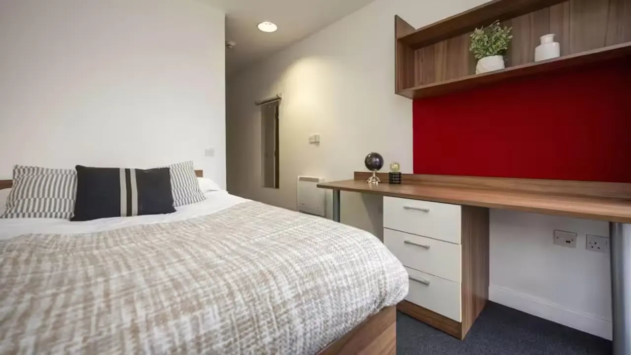 Bed with pillows desk with globe and shelves Bedroom at The Apollo Works in Coventry Student Accommodation