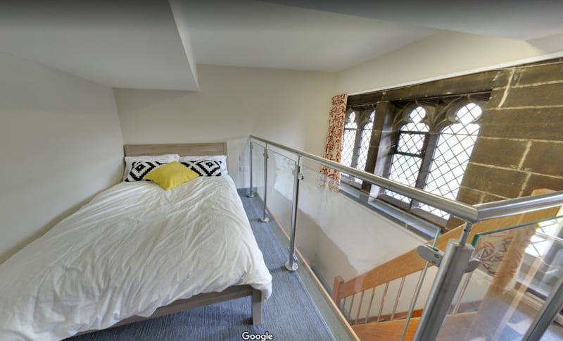 Bed with pillows and window overlooking stairs bedroom at The Priory in Leeds Student Accommodation
